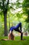 A little girl trains for yoga, does a backbend and stands on her hands in the park on the lawn