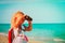 Little girl travel on beach, looking through binocular