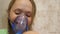 Little girl treated with an inhalation mask on her face in hospital. child with a tablet is sick and breathes through an