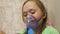 Little girl treated with an inhalation mask on her face in hospital. child with a tablet is sick and breathes through an