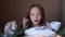 A little girl tries powdered sugar with her finger from a christmas stollen while sitting at the table