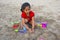 Little girl trying to make a fort with sand on Alibag beach, India