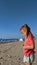 Little girl trying to untangle her kite string on the beach