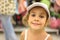 Little girl trying white cap in store