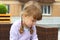 Little girl with two braids sits on wicker couch