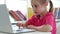 Little girl typing on laptop keyboard