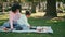 Little girl typing tablet sitting picnic with mother. African family relaxing