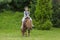 Little girl in Ukrainian national costume rides a pony