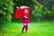 Little girl with umbrella playing in the rain