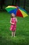 Little girl under colorful umbrella