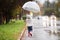 Little girl under the transparent umbrella outside, rainy day.