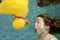 Little girl underwater swimming with rubber duck