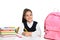 Little girl in uniform doing assignment at desk against white background.