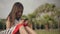 Little girl uses a smartphone on a green lawn with palm trees