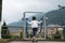 Little girl using the exercise equipment in the park to perform some workout in Sapa, Vietnam. Mountains on background