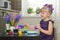 Little girl in the violet dress decorating easter eggs