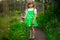 Little girl walk in green garden in sunny day