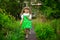 Little girl walk in green garden in sunny summer