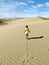 A little girl walk and leaves footprints on desert sand dune