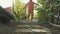 Little girl walking on path in garden. Close-up feet come near to camera.