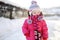 Little girl walking in purple wintercoat