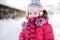 Little girl walking in a purple wintercoat