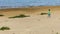 Little girl walking on a sandy shore of the lake