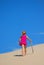 Little girl walking up sand dune