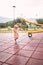 Little girl walks along the rubber surface of the playground to the swing-balancer