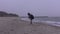 Little girl walks along the sea beach in autumn