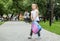 A little girl walks with a backpack in the schoolyard. The concept of school, study, education, childhood