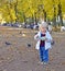 Little girl walks in gardens in fall