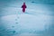 Little girl walks in winter nature leaving steps in snow
