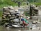 Little girl wash dishes in river - Nepal