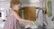 Little girl washing dishes with sponge in kitchen sink at home