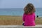 Little girl watches the sea alone