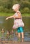 Little girl in water feeding ducks