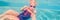 The little girl in the water park swimming underwater and smiling BANNER, LONG FORMAT