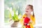 Little girl watering spring flowers