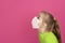 Little girl wear PP non-woven disposable medical face mask on pink background