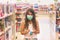 Little girl wearing disposable medical mask, in supermarket, during coronavirus outbreak