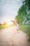 Little girl wearing dress is walking and look away from down rural road.