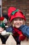 Little girl wearing elf hat and holding an elf toy