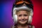 Little Girl Wearing Helmet and Goggles Against Purple and Red Background