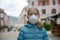 A little girl, wearing a medical mask, empty town on the background