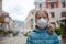 A little girl, wearing a medical mask, empty town on the background