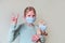 Little girl wearing protect mask and hugging bear toy in mask. Coronavirus protecting concept. Victory sign.