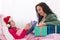 Little girl wearing Santa hat receiving her gift