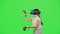 The little girl wearing VR headset gaming in virtual reality boxing game. The cute child fighting on chroma key green