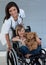 Little girl on a wheelchair holding her teddy bear